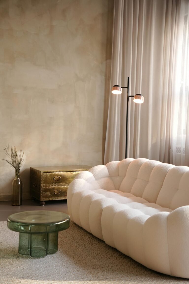 Sala de estar em estilo Japandi com sofá bouclé claro, paredes texturizadas e iluminação suave